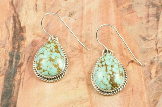 Genuine Number 8 Mine Turquoise Stones set in Sterling Silver French Wire Earrings. The Number 8 mine is located in Eureka County Nevada. Since 1976 there has been no Number 8 Turquoise mined. There is however, an existing stock pile that Mr. Dowell Ward, the last owner of the Number 8 mine, had stocked away for later sorting. The Turquoise is a collector's item--because once the reserve is gone there will be no more material released onto the market. The Gold Mining Company owns the claim to the Number 8 mine and it has been swallowed up by the gold mining operations. This is some of the last Number 8 Turquoise to be had and will be a great addition to your collection. Created by Navajo Artist Mike Ganadonegro. Signed by the artist.